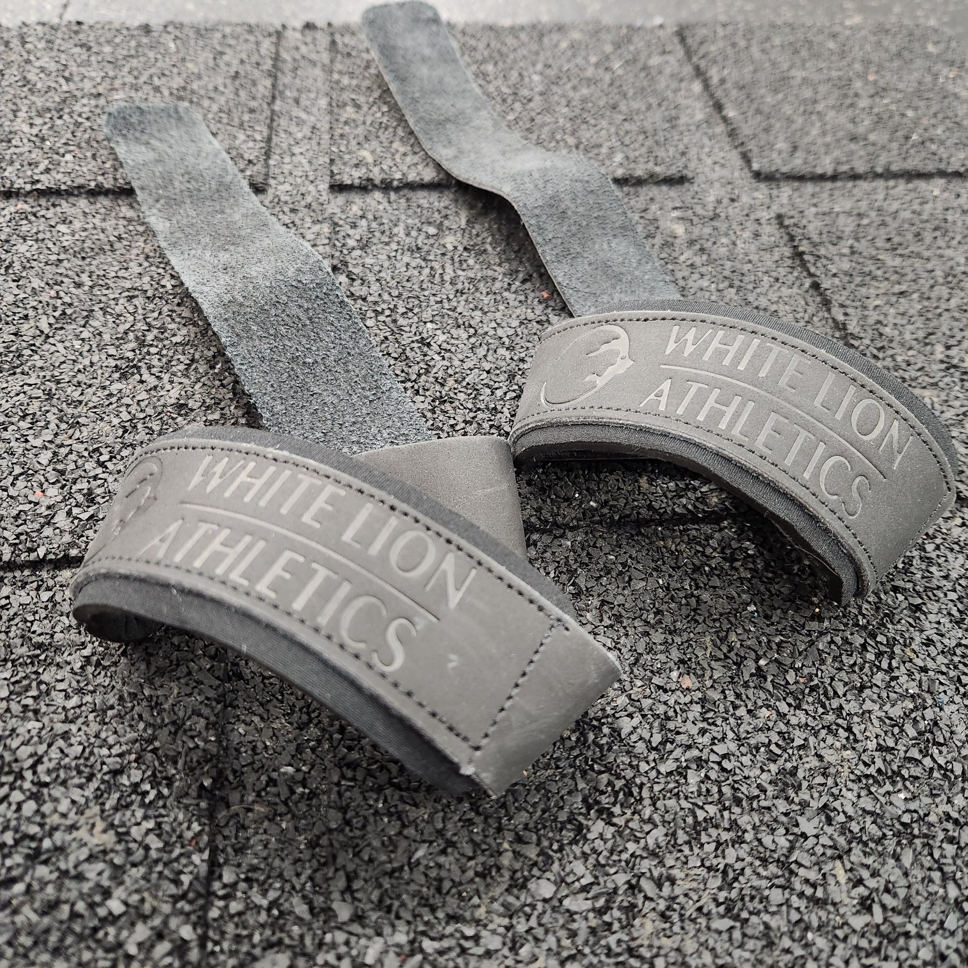 Close  up shot of a pair of black leather weights straps by White Lion Athletics.