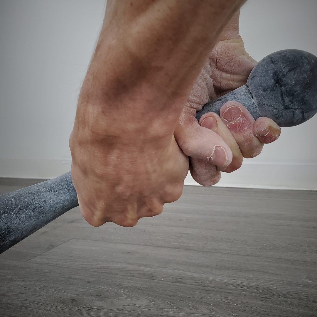 Gym chalk by White Lion Athletics being used on hands while training with a steel club.