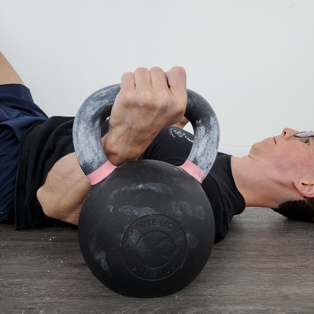 Gym chalk by White Lion Athletics being used on hands while training with a Kettlebell.