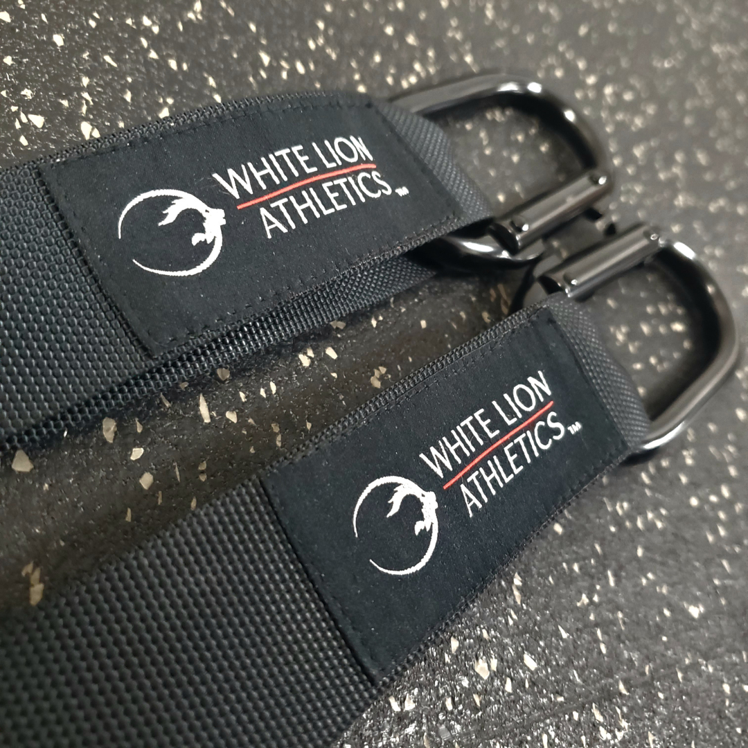 Close-up shot of the fabric logos stitched onto the White Lion Athletics competition straps for gymnastics rings.