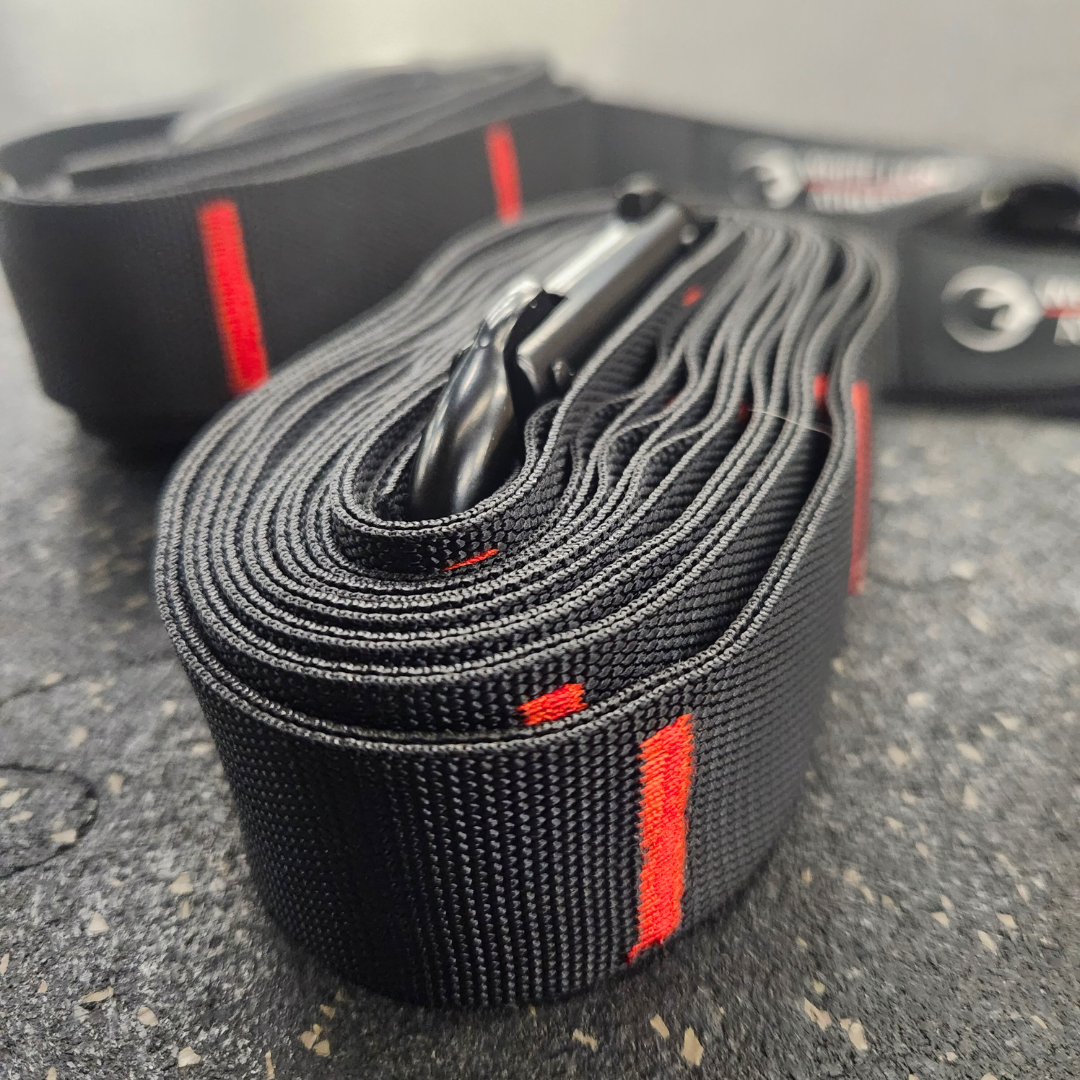 A close up shot of the two inch, black heavy duty webbing and red coloured triple stitching on the competition straps for gymnastics rings made by White Lion Athletics.