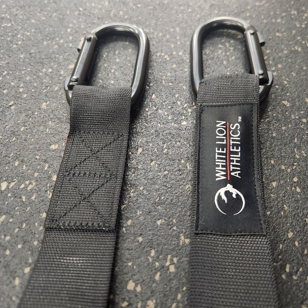 Close-up shot of the fabric logos stitched onto the White Lion Athletics competition straps for gymnastics rings.