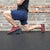 Performing a front foot elevated split squat on a 20 degree elevated steel squat wedge by White Lion Athletics