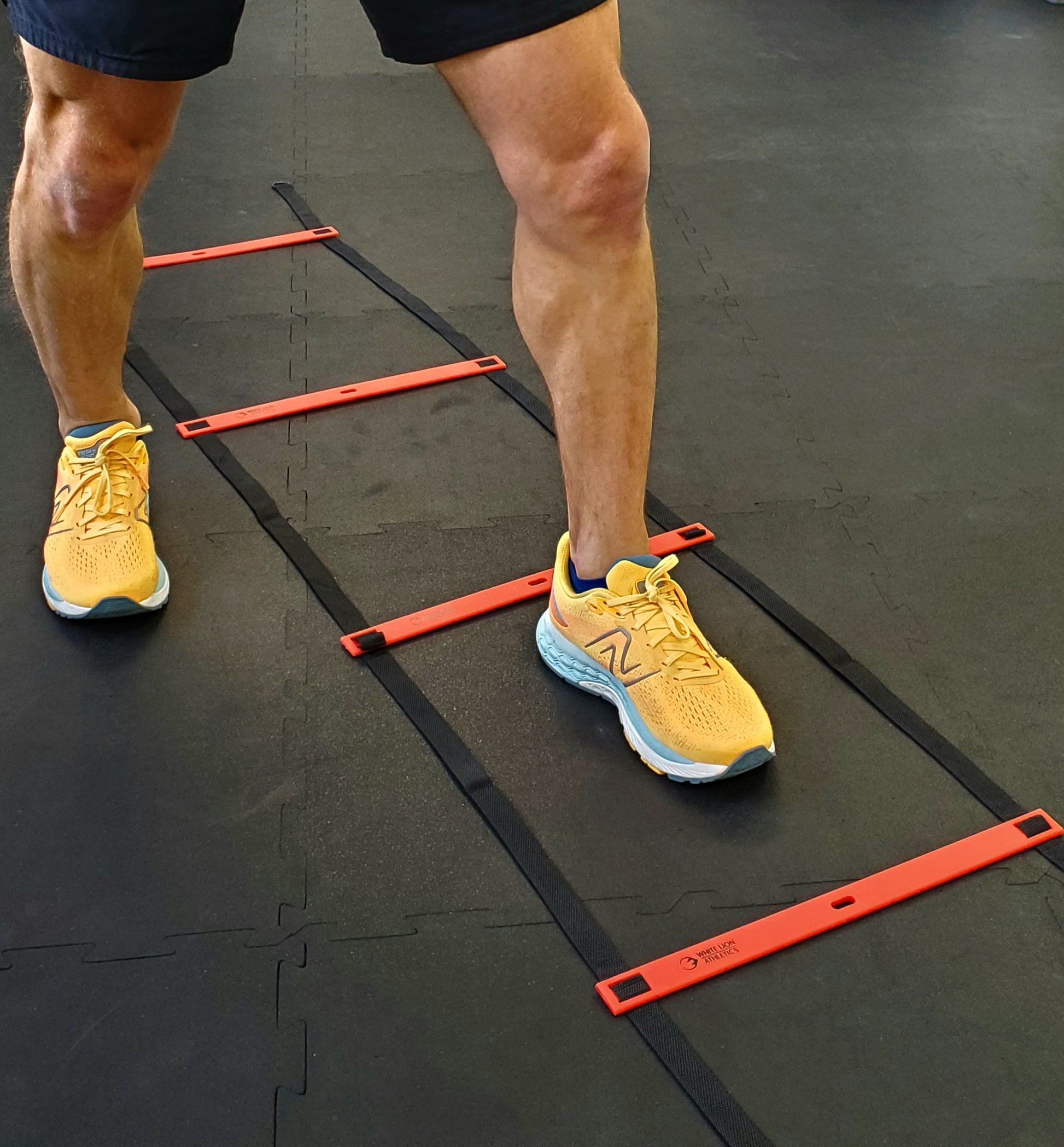 The left foot of an athlete is shown in the centre of the agility ladder while performing an agility drill with the six metre long White Lion athletics agility ladder