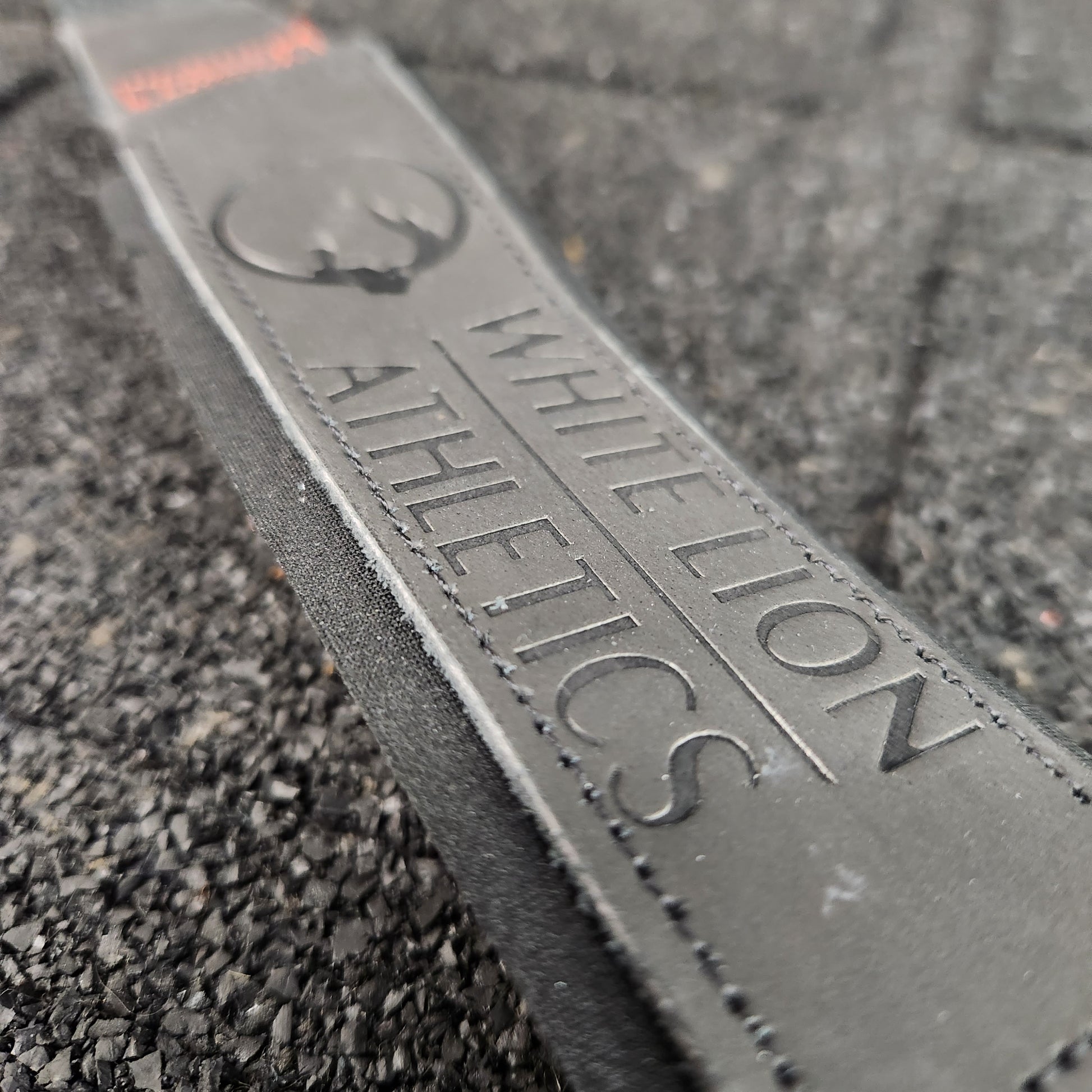Close up shot of embossed logo on leather weightlifting straps by White Lion Athletics.