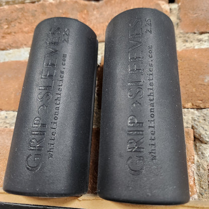 a pair of 2.25" Grip Sleeves by White Lion Athletics displayed against brickwall
