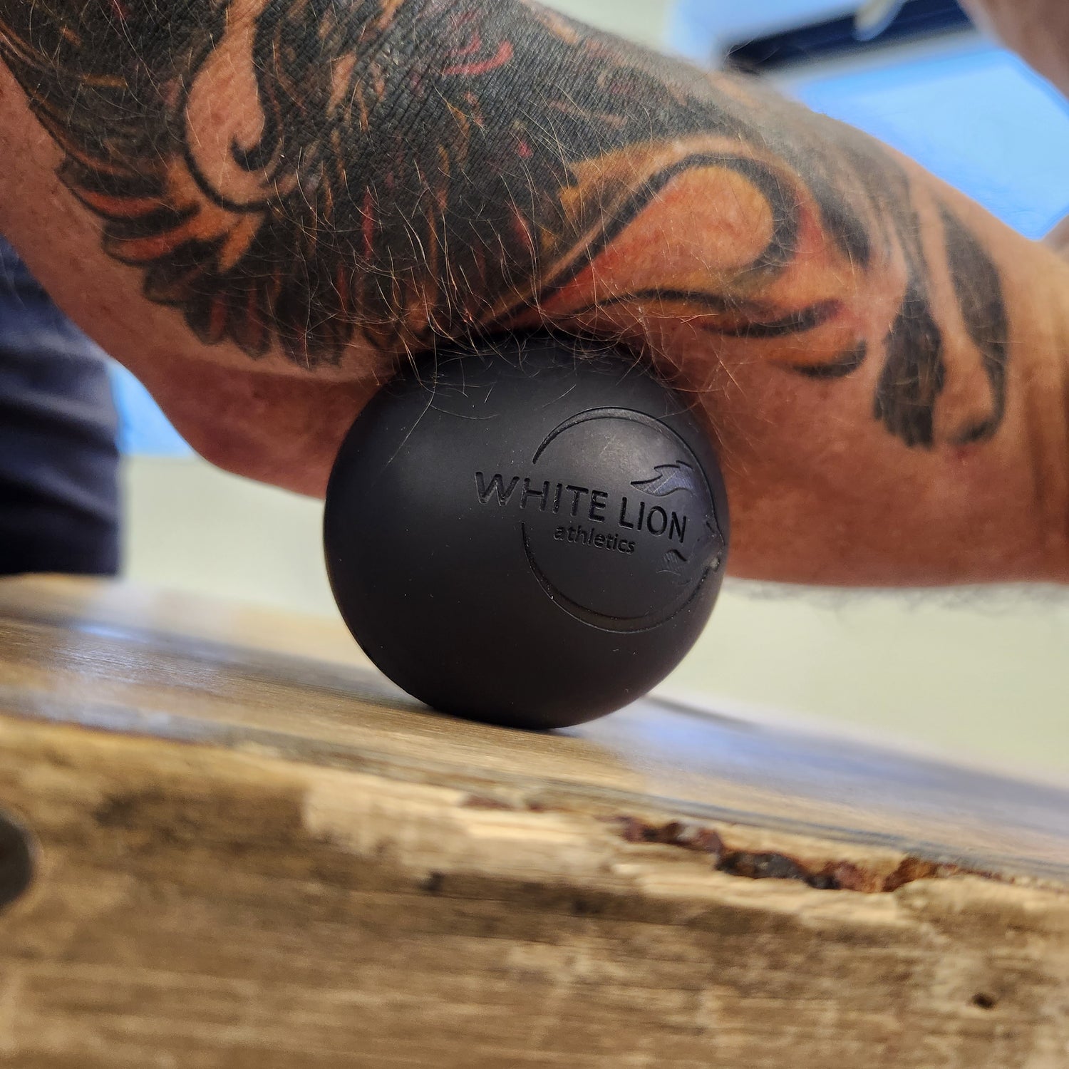 Lacrosse ball being used on forearm for self-massage 