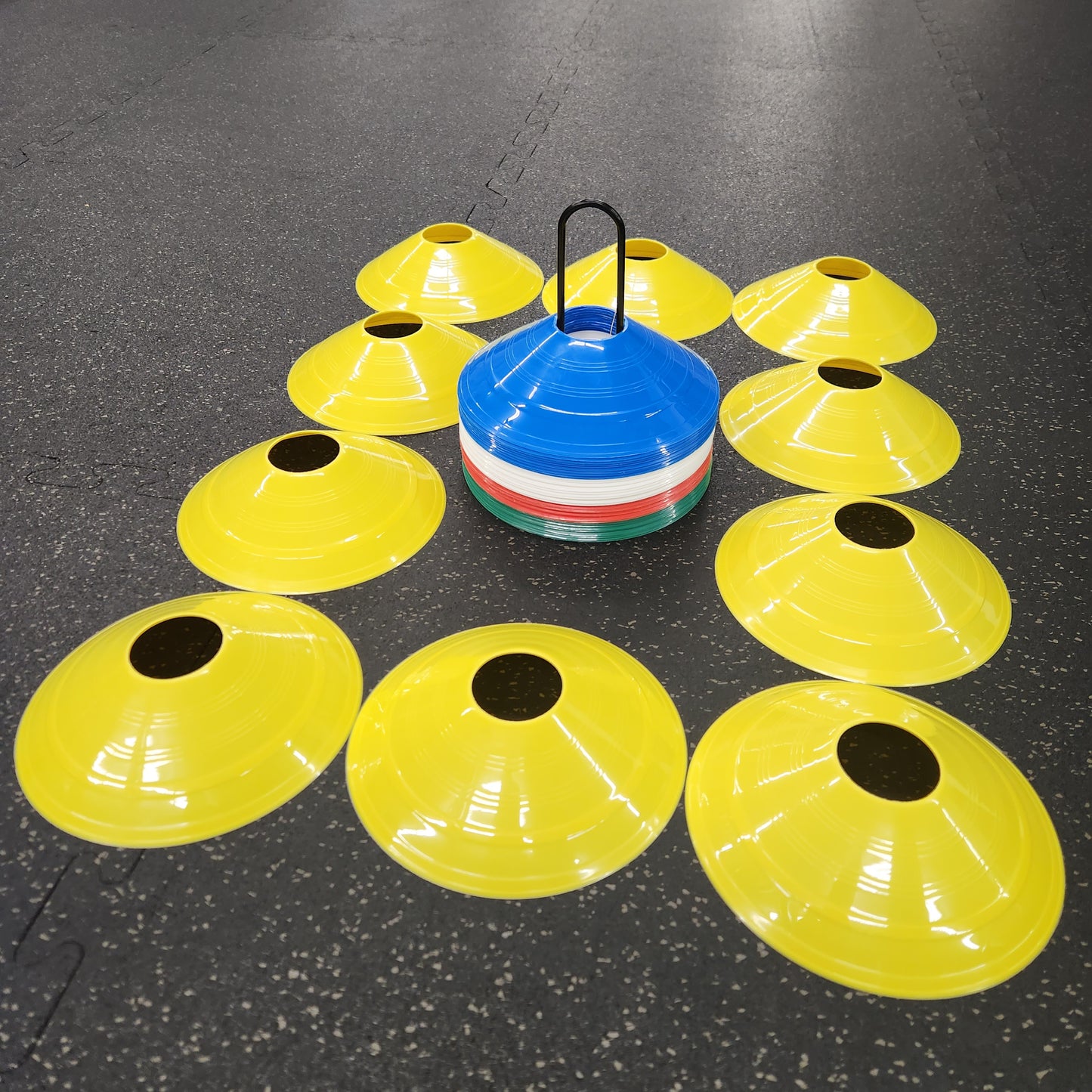 10 yellow agility cones encircling a black metal stand with agility cones on it.