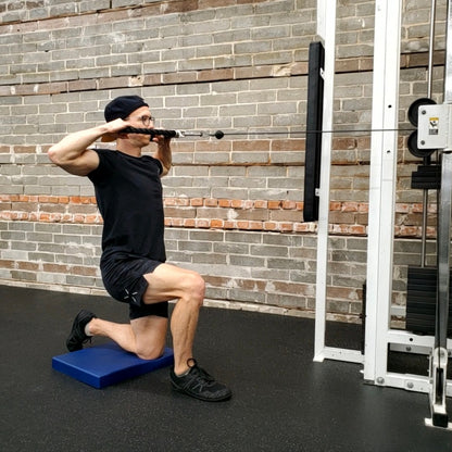 half kneeling cable facepull exercise while kneeling on White Lion Athletics Balance Pad.